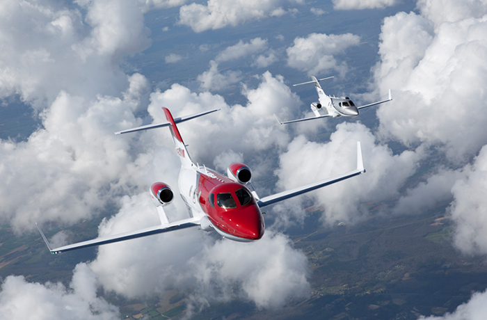 HondaJet rouge et argent volant dans le ciel.